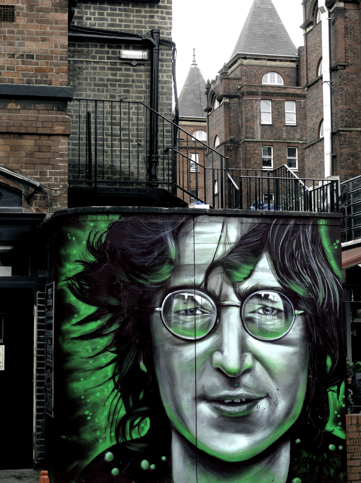 Un portrait de John Lennon tagué sur un mur à Camden. Des bâtiments de briques rouges, le ciel, là bas, juste le ciel...